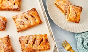 Goldbraune Apfeltaschen, frisch aus dem Ofen, bestäubt mit Puderzucker. Ein köstliches Apfeltaschen Rezept zum Nachbacken.
