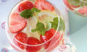 Erfrischendes Erdbeerbowle Rezept: Fruchtige Erdbeeren, Zitronenscheiben und Minze in einem Glas. Perfekt für heiße Tage!