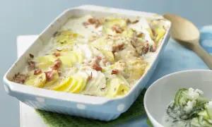 Herzhafte Kohlrabi-Rezepte: Kartoffel-Kohlrabi-Auflauf mit Speck und cremiger Sauce, dazu Gurkensalat.