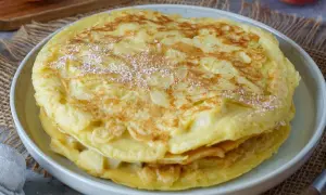 Ein gestapelter Apfelpfannkuchen, bestäubt mit Puderzucker. Ein köstliches Apfelpfannkuchen Rezept, das man ausprobieren muss!
