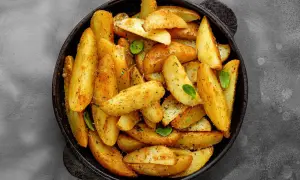 Goldbraune Ofenkartoffeln mit Kräutern und Gewürzen in einer Pfanne. Perfekt für ein einfaches Ofenkartoffeln Rezept.