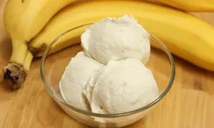 Schüssel mit cremigem Bananeneis, daneben reife Bananen. Perfekt, um Bananeneis selber machen zu können!