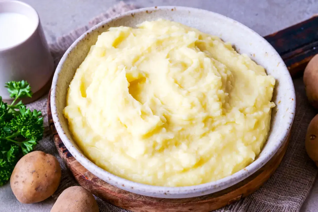 Cremiger Kartoffelbrei, perfekt für jedes Kartoffelbrei Rezept. Dazu ein Krug Milch und frische Petersilie.