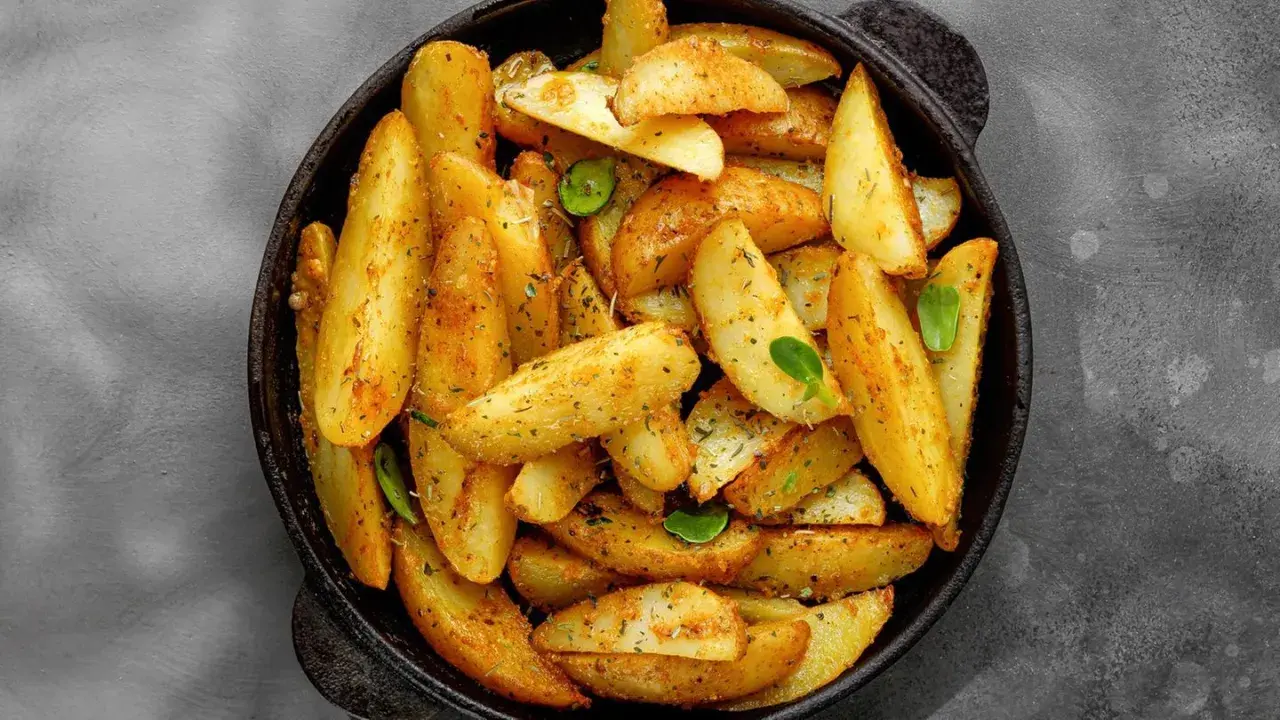 Goldbraune Ofenkartoffeln mit Kräutern und Gewürzen in einer Pfanne. Perfekt für ein einfaches Ofenkartoffeln Rezept.