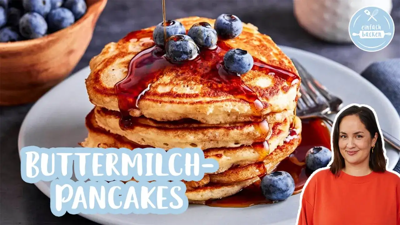 Fluffige pancakes mit Blaubeeren und Sirup, dazu eine lächelnde Frau.