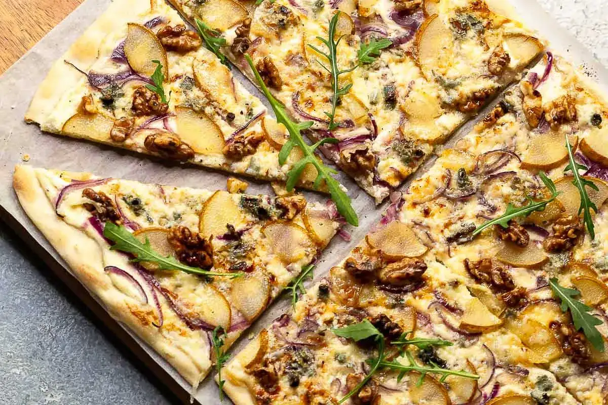 Flammkuchen mit Birne, Walnüssen und roter Zwiebel. Ein köstlicher Flammkuchen Belag, der süß und herzhaft kombiniert.